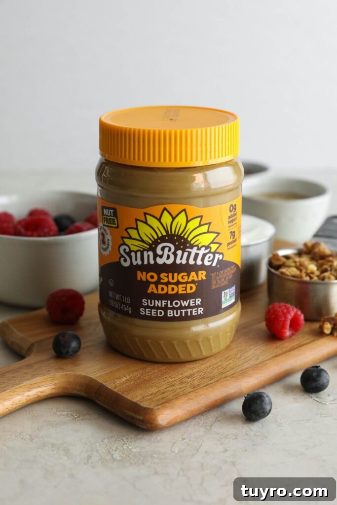 SunButter jar on wooden board with berries and granola