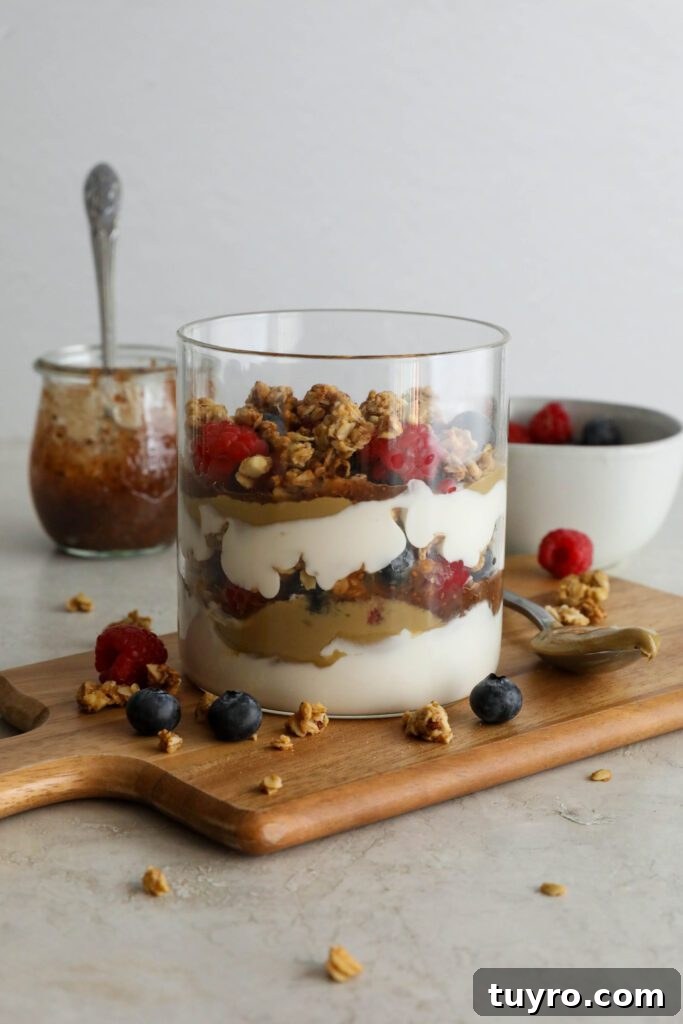 SunButter Berry Spring Parfait in glass jar on wooden board with berries and granola sattered
