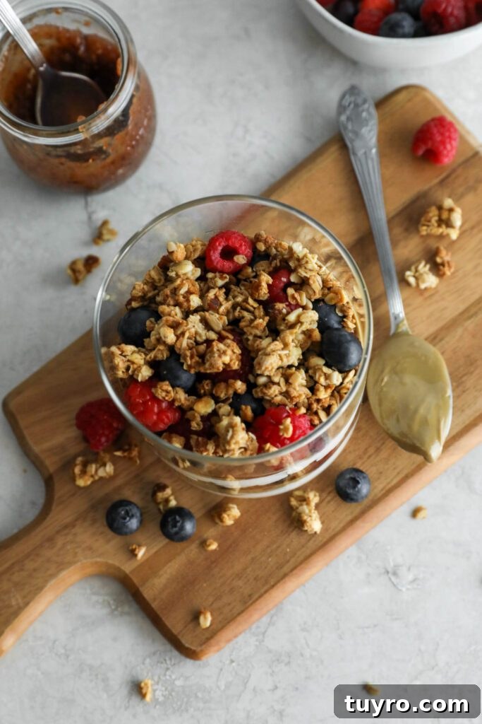 SunButter Berry Spring Parfait in glass jar on wooden board with berries and granola sattered