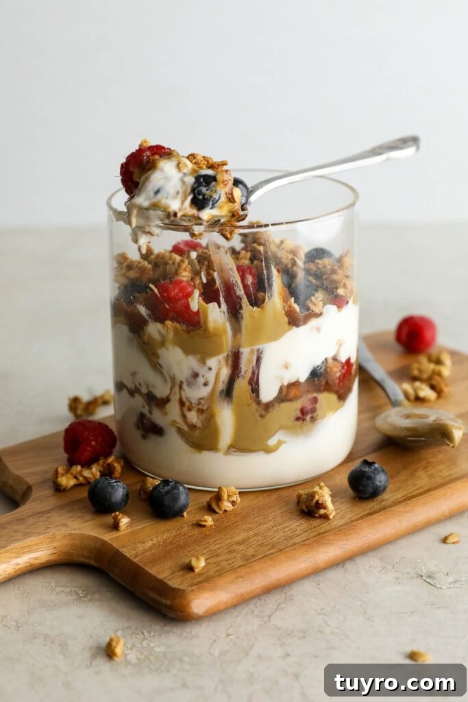 SunButter Berry Spring Parfait in glass jar on wooden board with berries and granola sattered