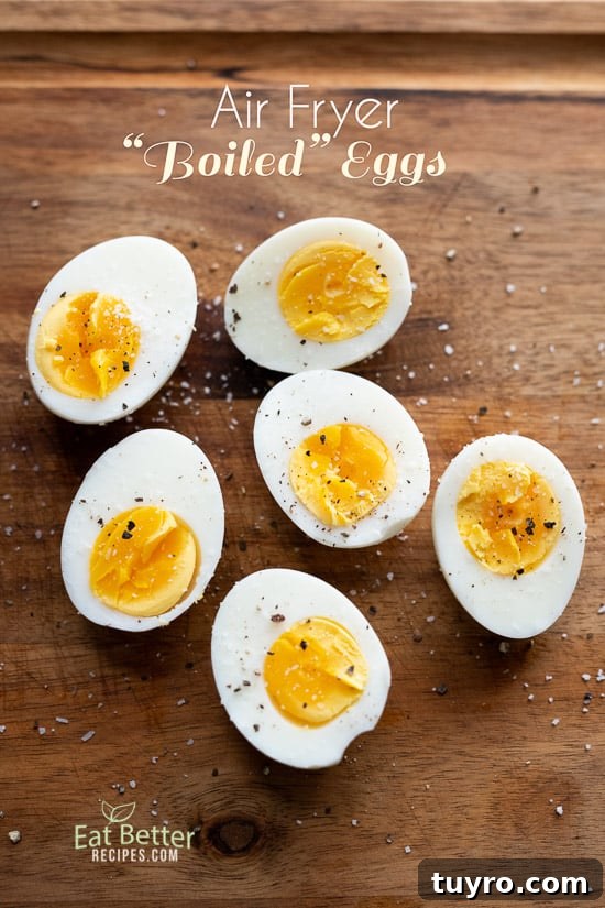 Air Fryer Boiled Eggs and How to Cook Eggs in Air Fryer @EatBetterRecipes Air Fryer Boiled Eggs split in half on a cutting board