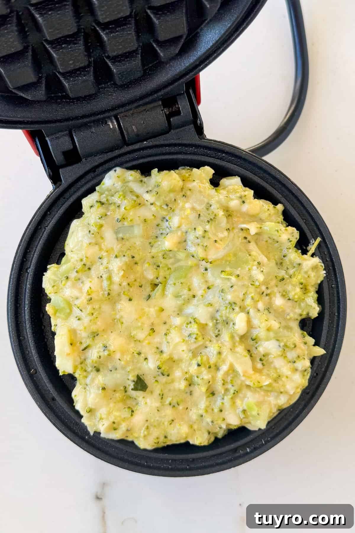 Broccoli Cheddar Waffles Recipe 7 Waffles cooking in waffle iron.