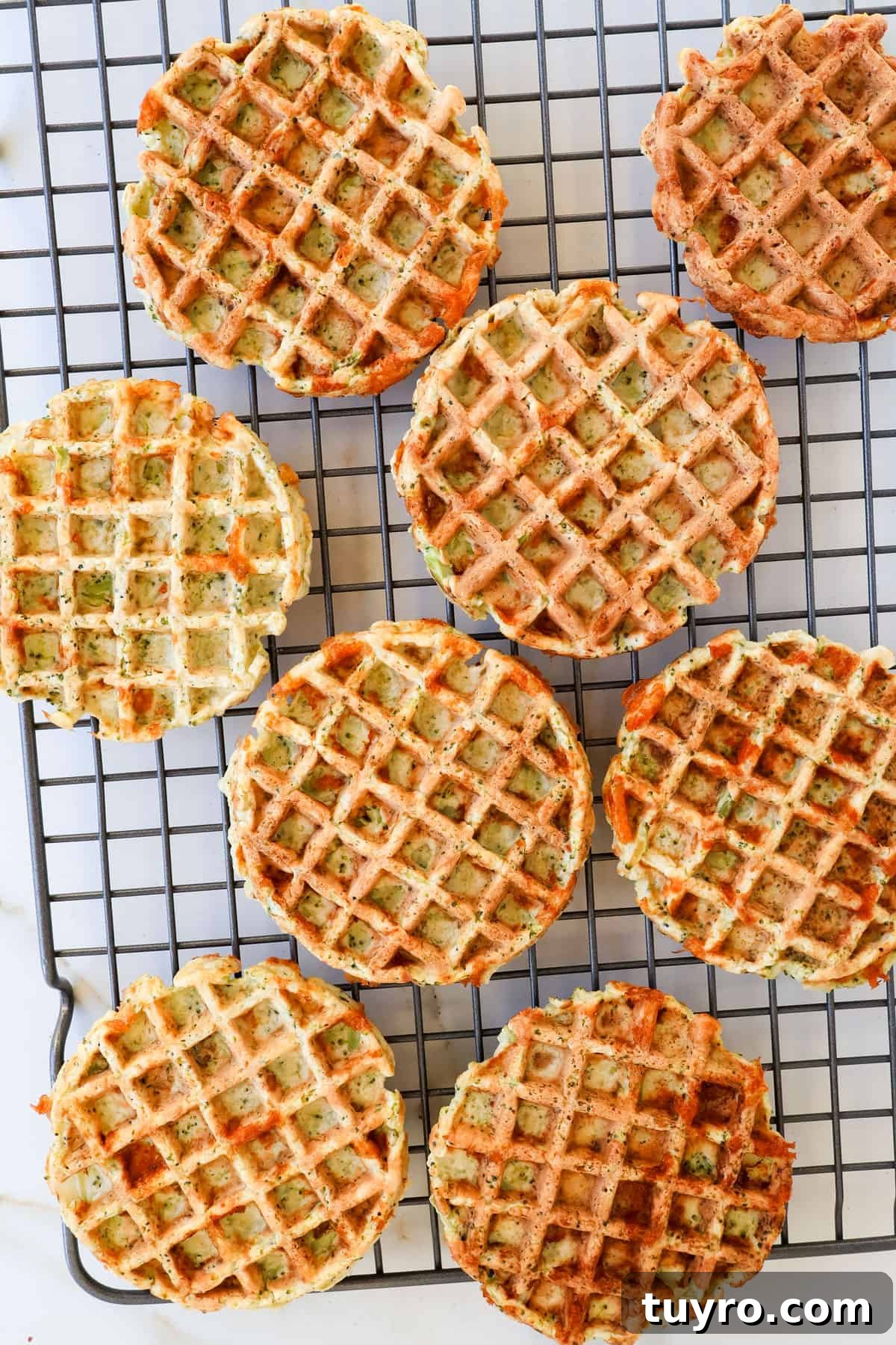 Broccoli Cheddar Waffles Recipe 8 Cooked waffles on a wire rack.
