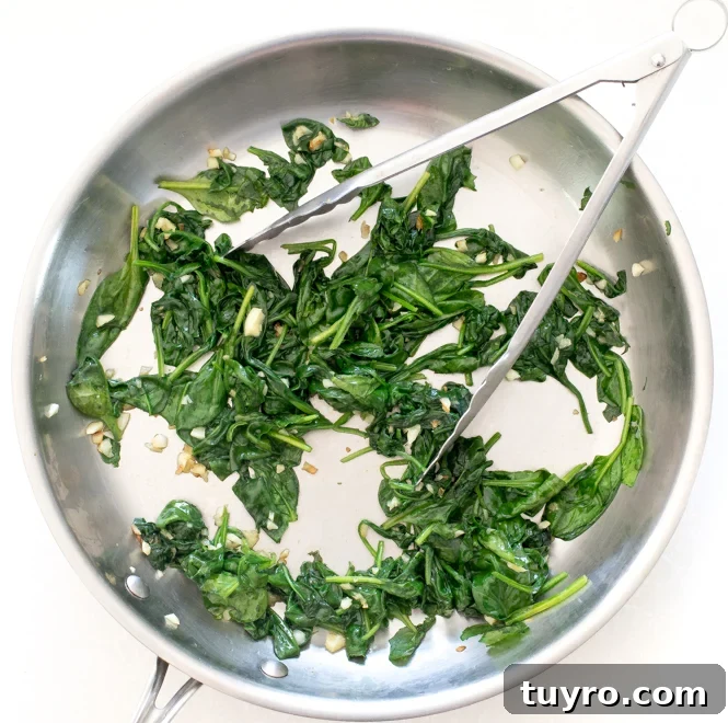 Creamy Walnut Pesto Pasta Recipe for Quick Weeknight Meals 8 Tongs in a skillet with arugula and spinach.