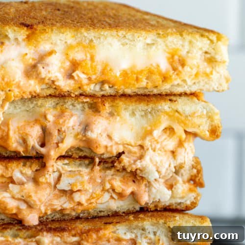 Stack of grilled cheese on black plate.