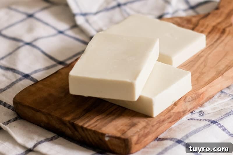 DIY Sunscreen Lotion Bar: Natural SPF Balm Recipe 4 DIY sunscreen bars stacked on wooden cutting board.