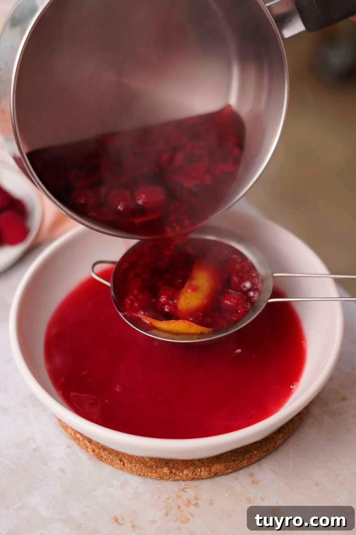 Raspberry Tiramisu Recipe: Light, Creamy Berry Dessert 8 straining raspberry syrup through a sieve