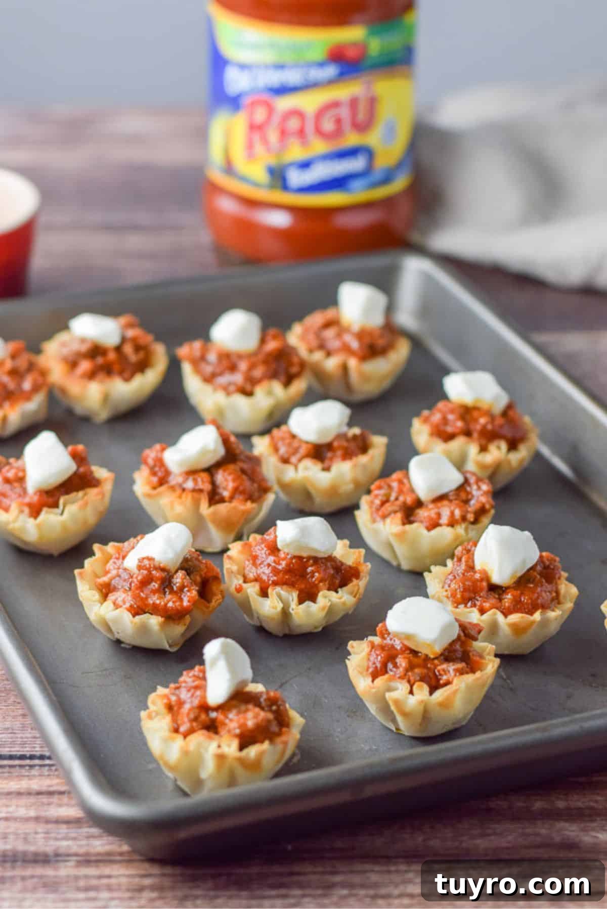 Savory Sauced Beef Bites: Perfect Party Appetizer Recipe 5 Pearl mozzarella placed on the beef appetizer with the jar of sauce in the background