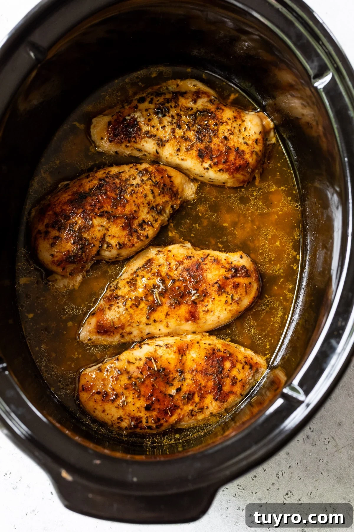Tender Slow-Cooker Chicken Breast Recipe for Quick Meals 6 chicken breasts cooking in a slow cooker.