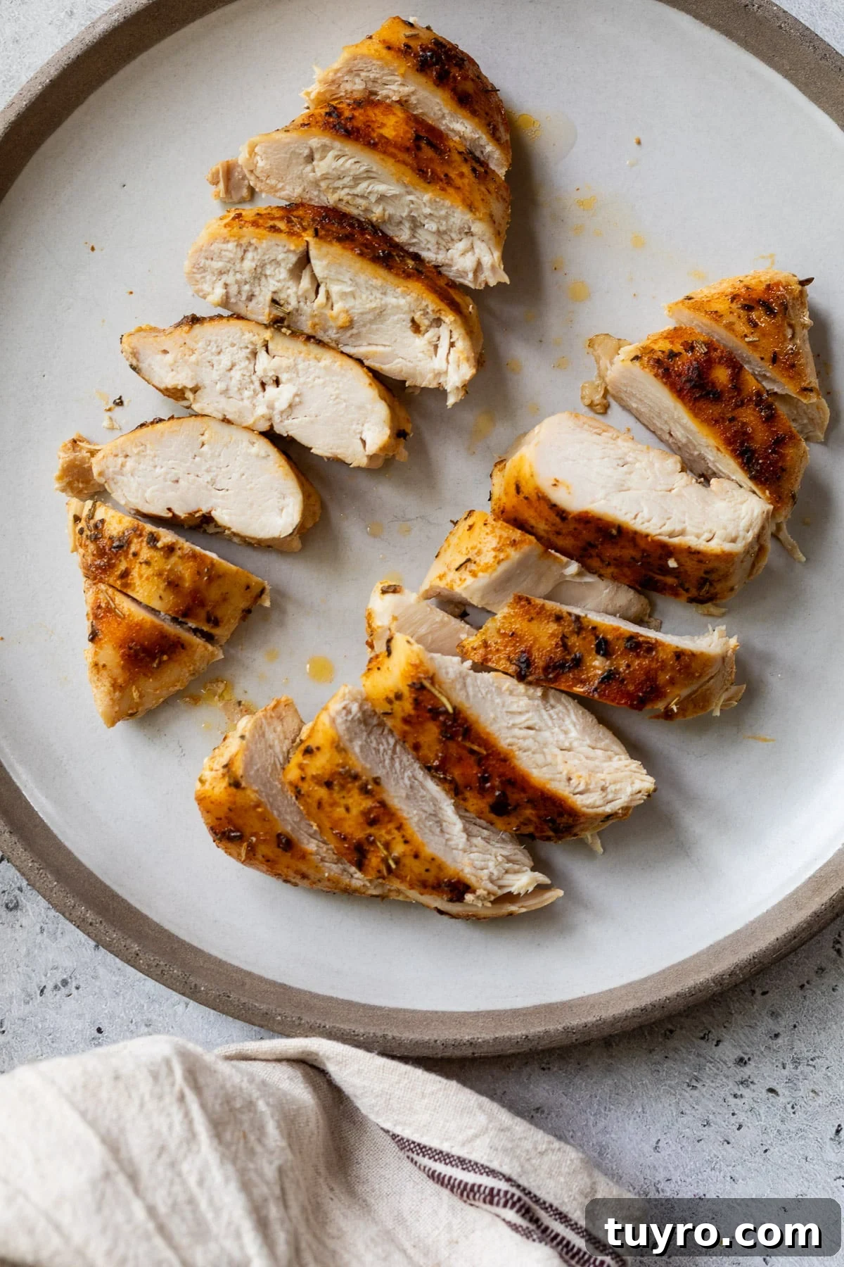 Tender Slow-Cooker Chicken Breast Recipe for Quick Meals 8 two sliced chicken breasts on a white plate.