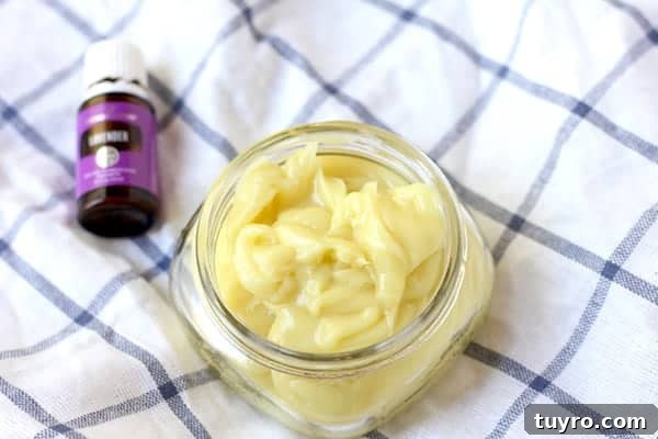 DIY Magnesium-Infused Body Butter Recipe for Smooth Skin 3 Photo shows a jar of body butter on a cloth, next to a small jar of essential oils