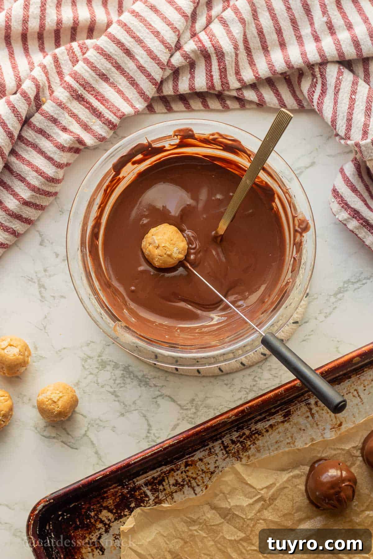 No-Bake Peanut Butter Rice Krispie Balls 9 Dipping peanut butter balls into bowl of melted chocolate.