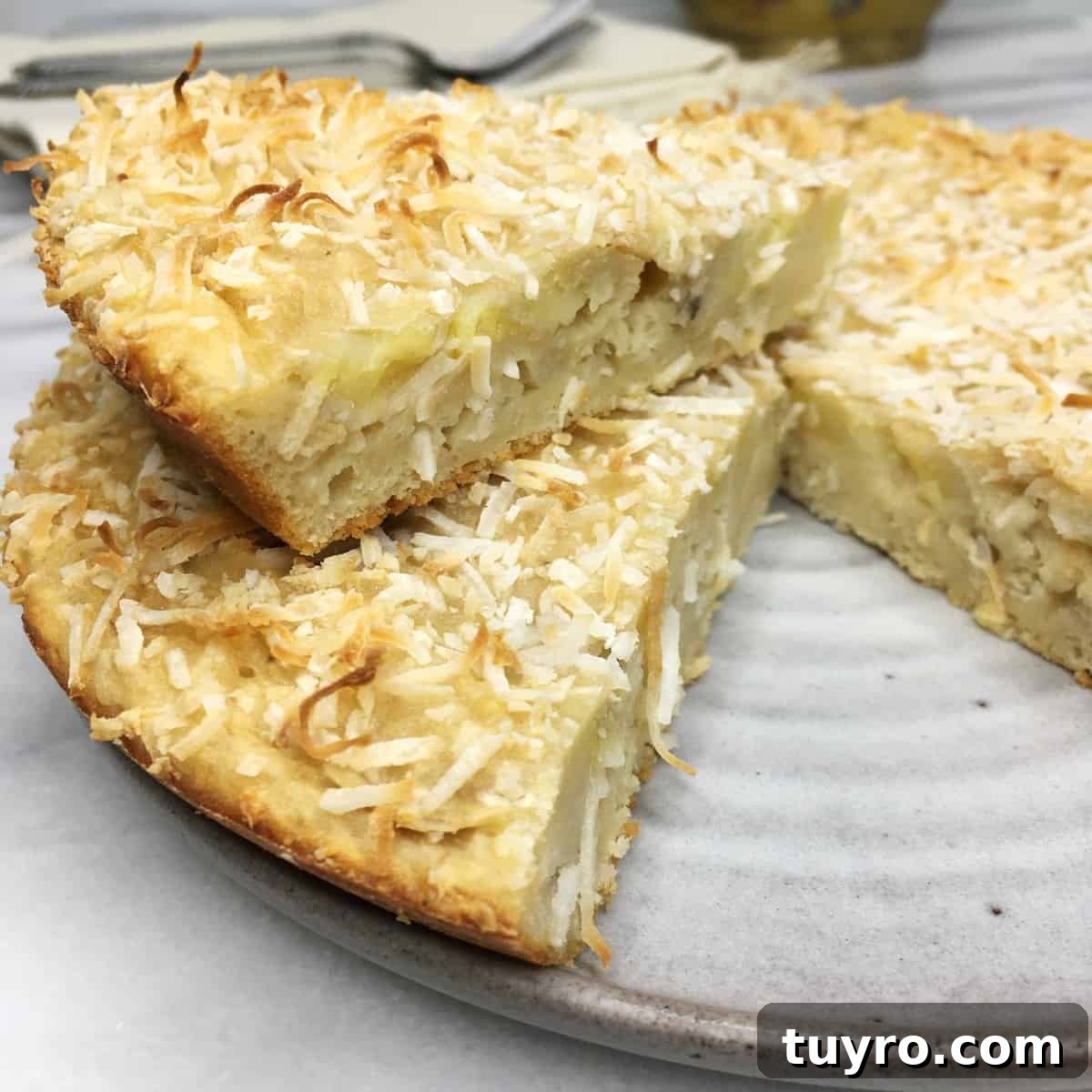 Sliced sugar-free banana coconut cake on a grey dessert plate.