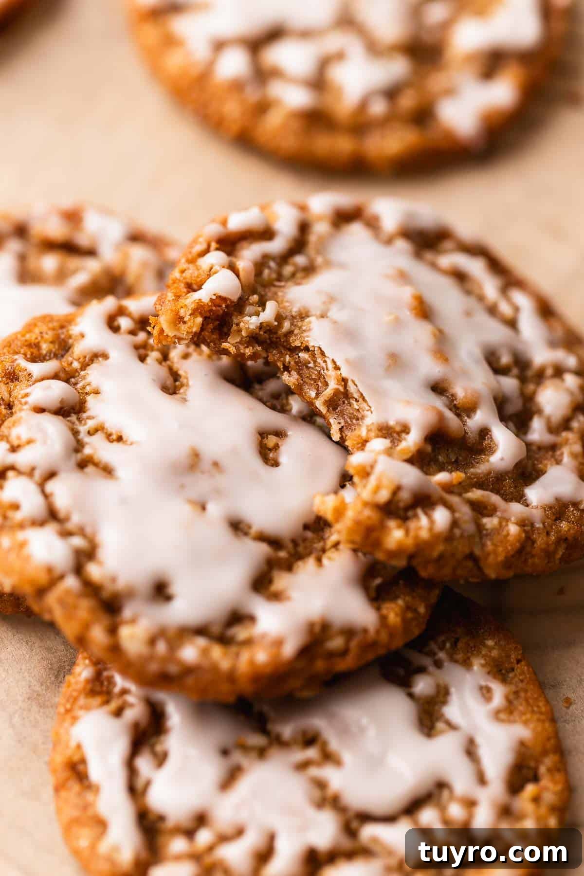 Soft Iced Oatmeal Cookies Recipe with Chewy Texture and Vanilla Glaze 6 Frosted oatmeal cookie with a bite taken out of it to show the chewy texture.