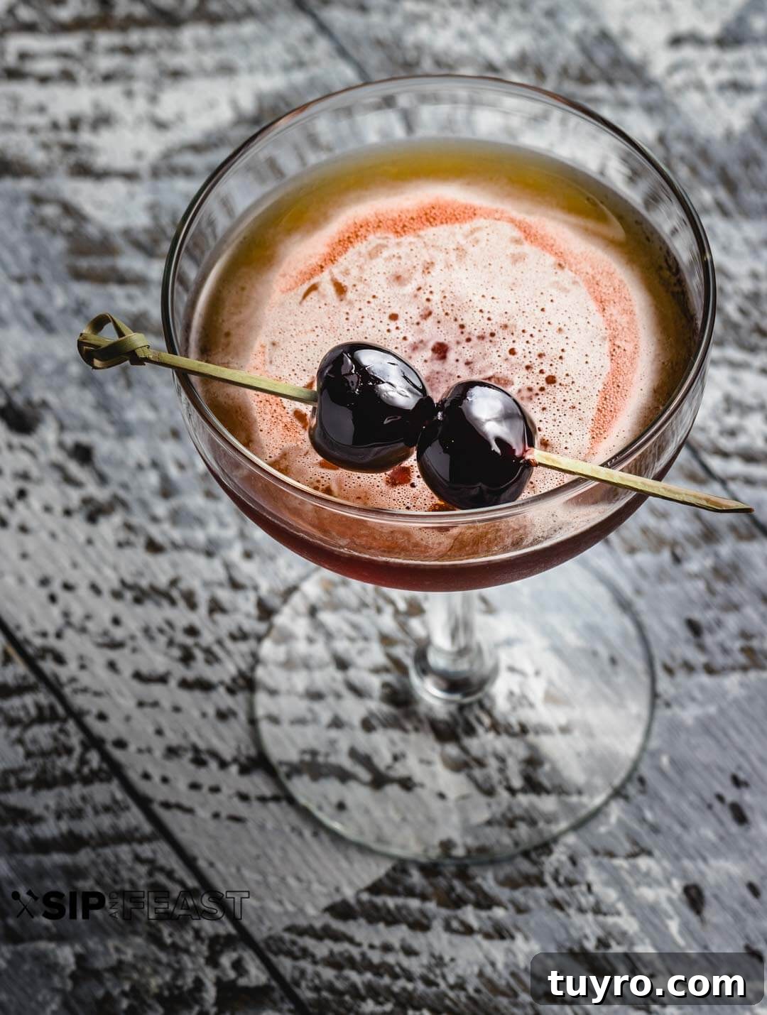 Perfect Manhattan Recipe - sipandfeast.com #manhattan #cocktails #amarenacherries #rye A glass of the perfect Manhattan recipe and two amarena cherries on a skewer.