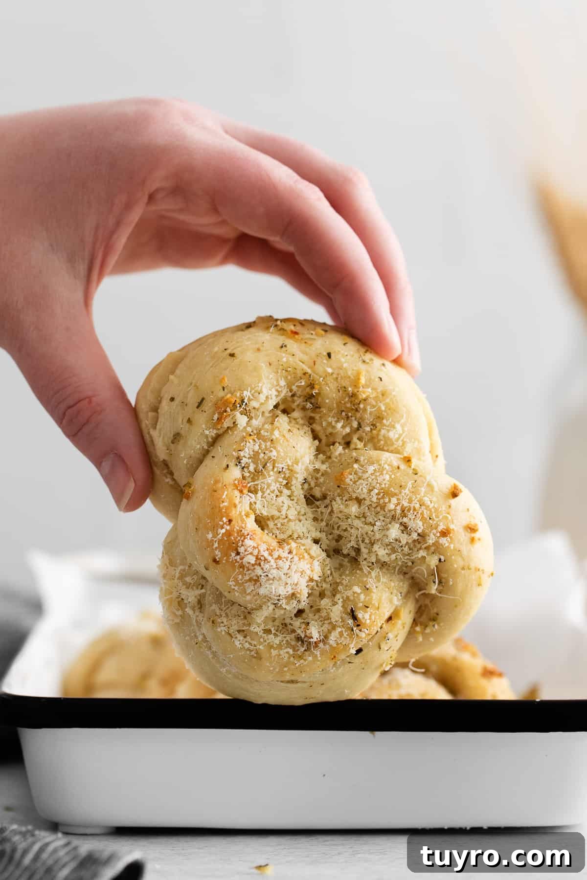 Homemade Parmesan Garlic Knots Recipe 8 A hand holding a garlic knot.