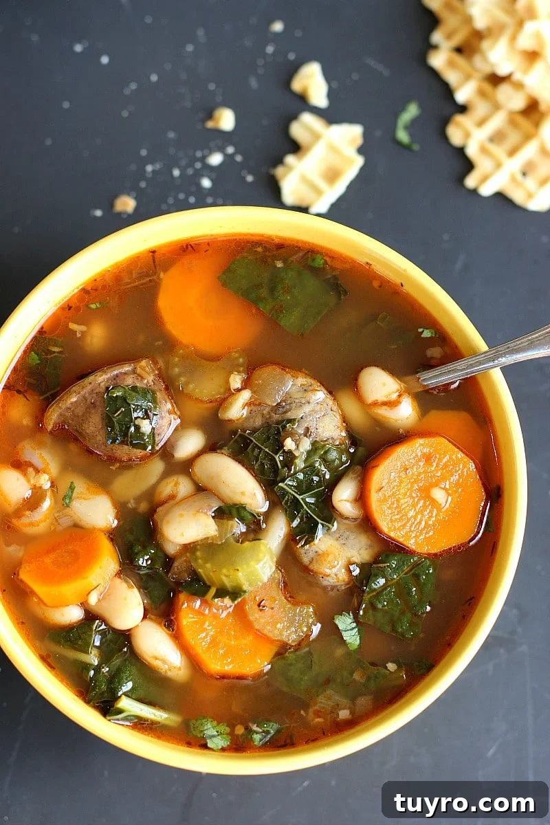 One-Pot Cannellini Bean, Sausage and Kale Soup 2 Cannellini Sausage Kale Soup in a white bowl with a spoon.
