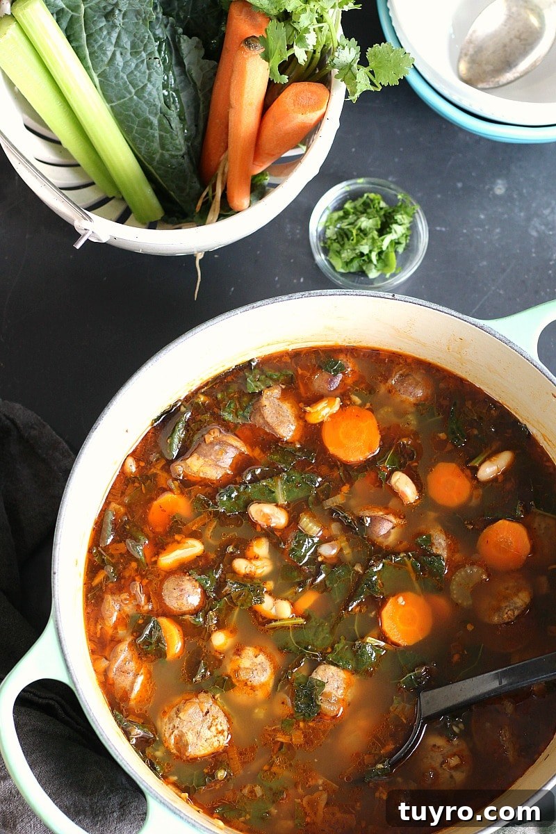 One-Pot Cannellini Bean, Sausage and Kale Soup 4 Cannellini Sausage Kale Soup, Swiss chard, celery, carrots, cilantro, spoon, and a blue bowl with a white bowl inside it.