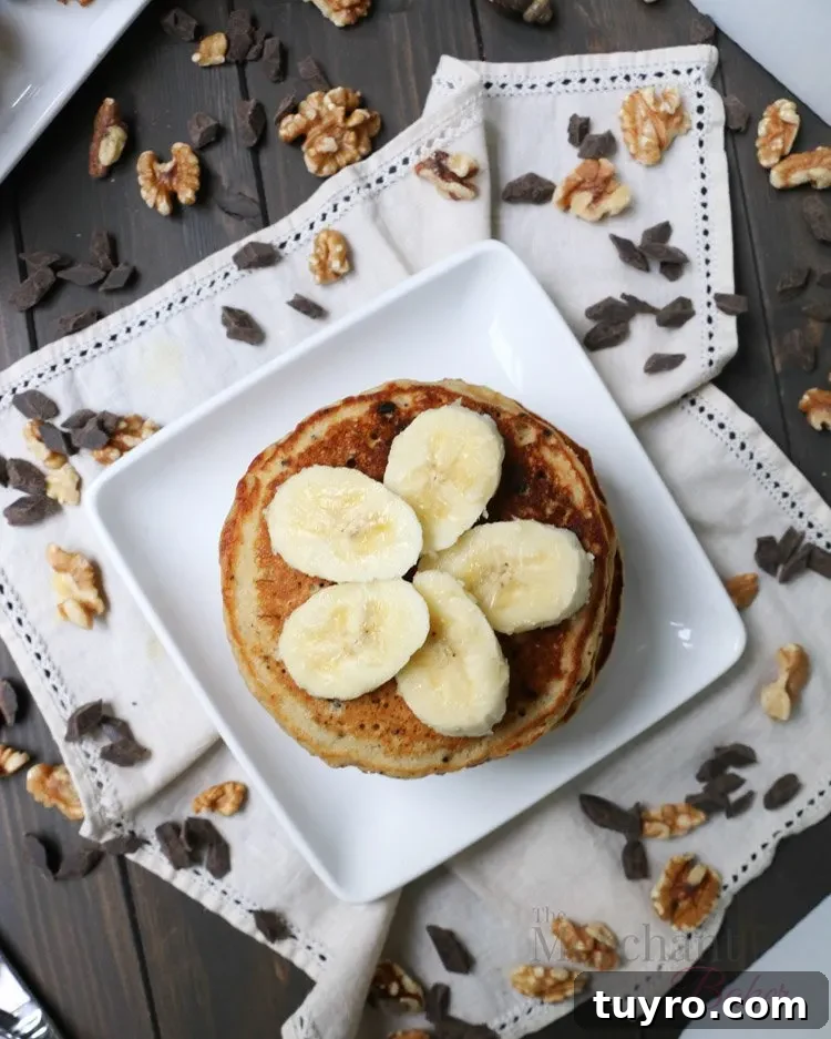 Overhead view of sliced bananas on top of a stack of Oatmeal Chocolate Chip Banana Pancakes