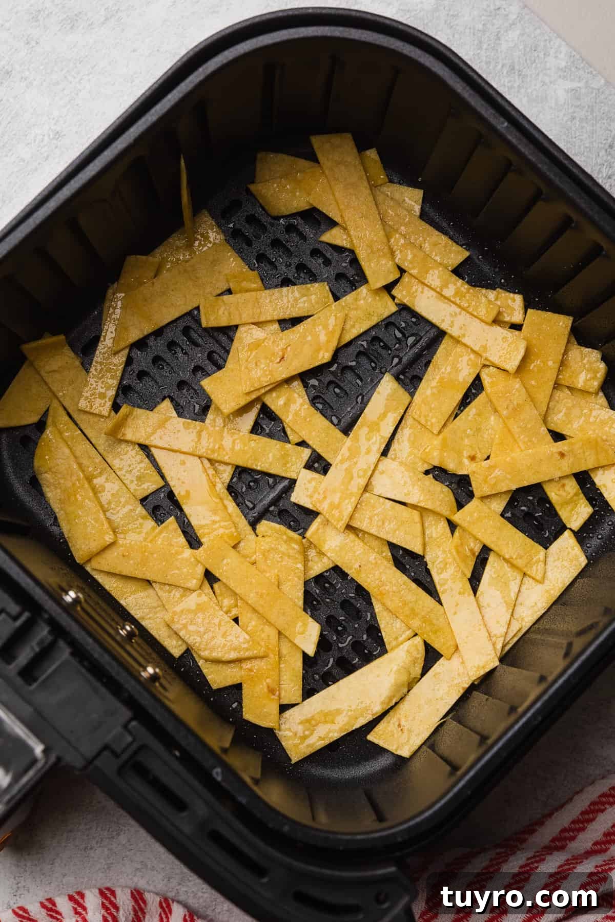 Crispy Air Fryer Tortilla Strips for Salads and Soups 5 Corn tortilla strips in the air fryer basket before cooking.