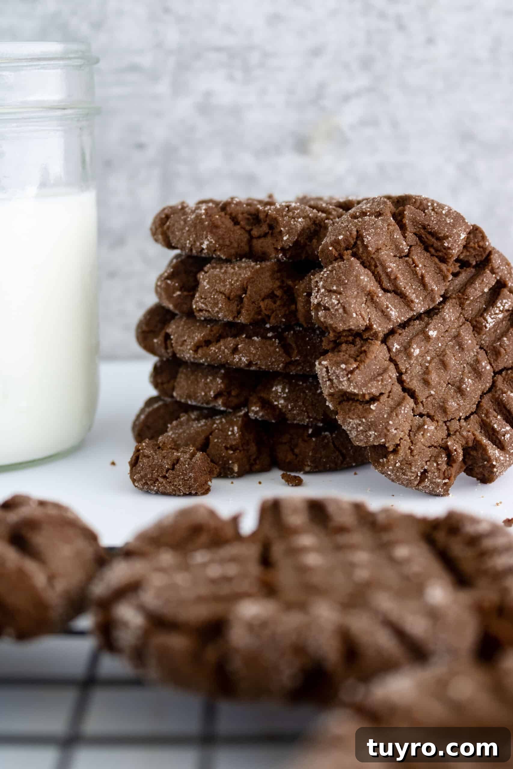 Chewy Chocolate Peanut Butter Cookies Recipe 2 chocolate peanut butter cookies next to a glass of milk.