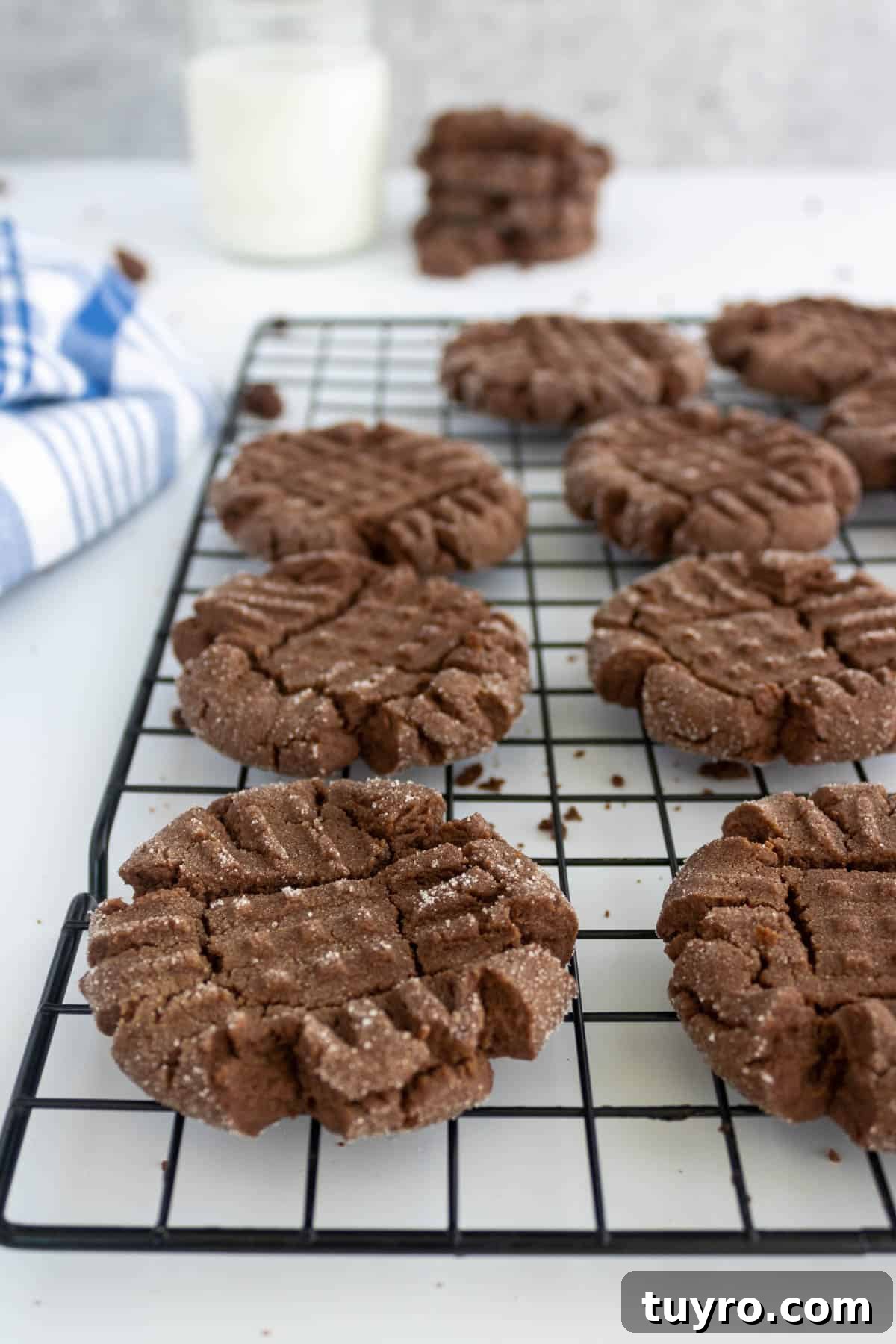 Chewy Chocolate Peanut Butter Cookies Recipe 8 cookies on a cooking rack by a glass of milk.