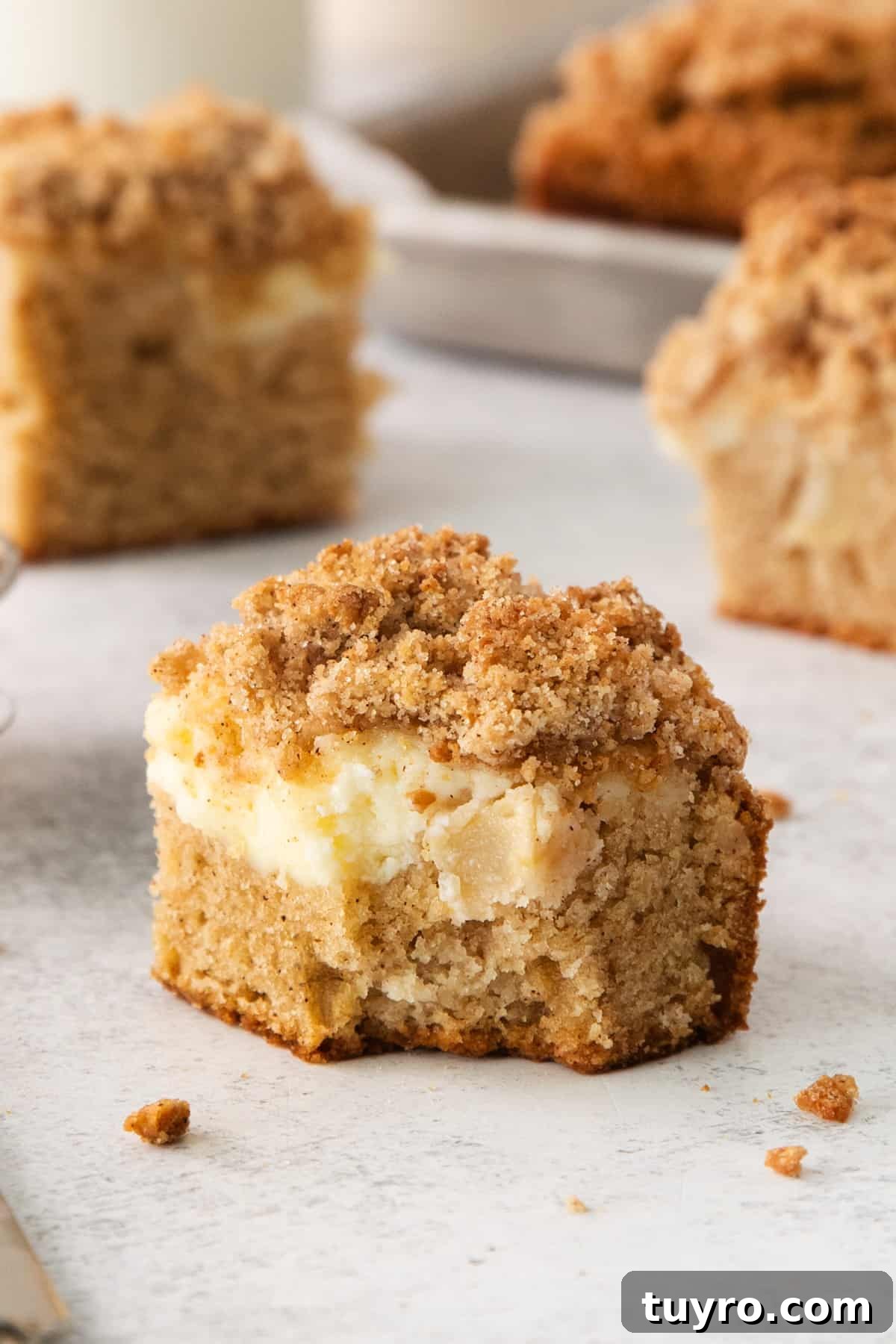 Homemade Apple Cream Cheese Coffee Cake Recipe 2 a close up of a muffin with a bite taken out of it.