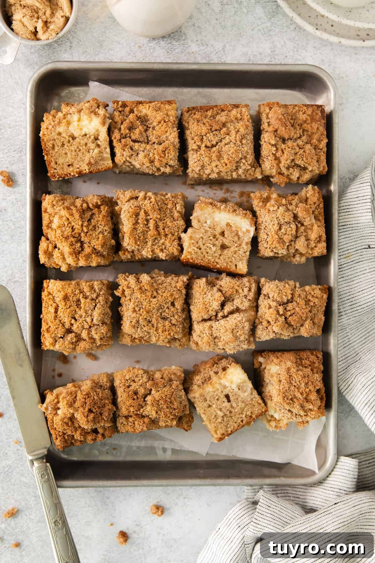 Homemade Apple Cream Cheese Coffee Cake Recipe 3 a pan filled with baked goods next to a cup of coffee.