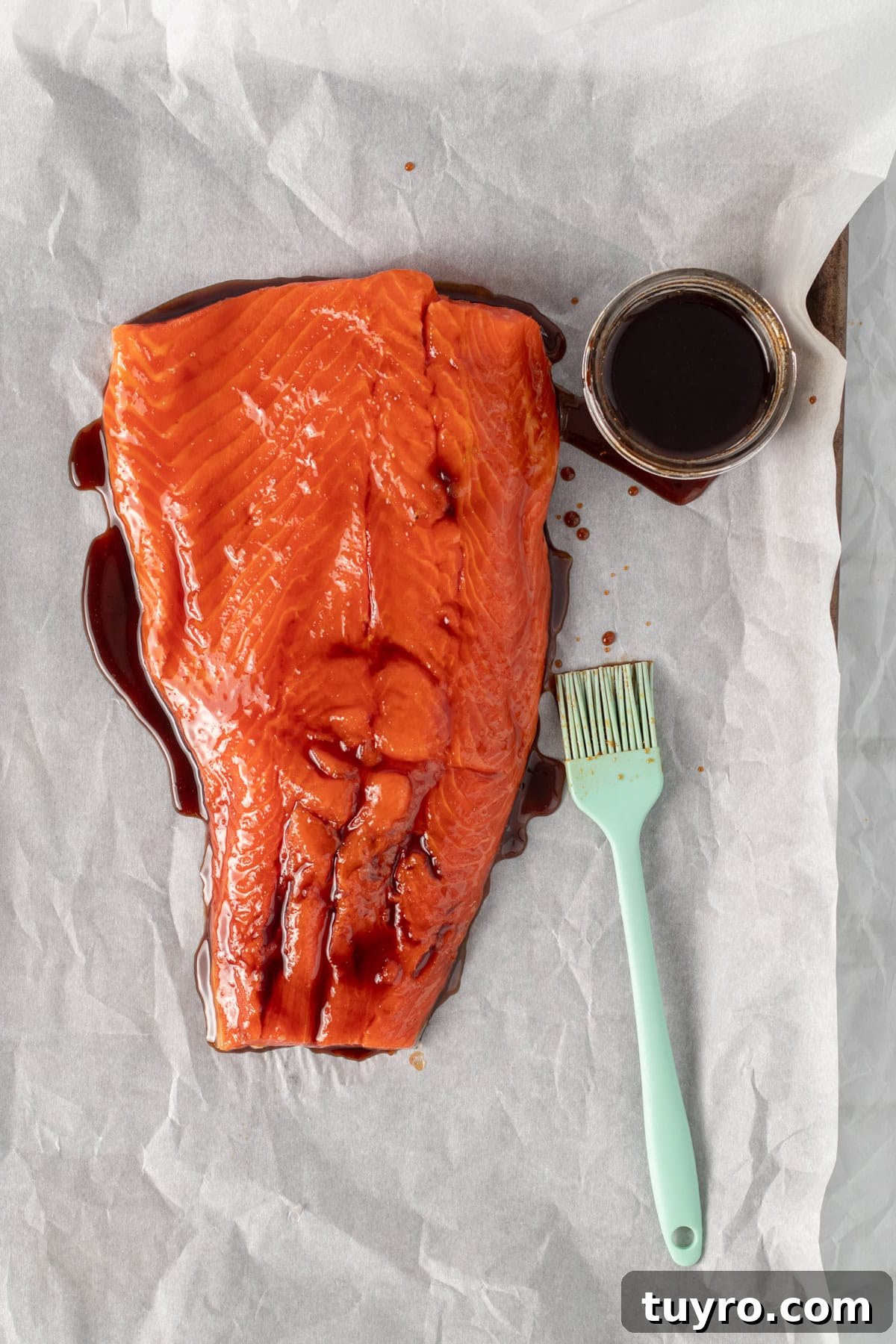 Baked Teriyaki Salmon in 15 Minutes — 2-Ingredient Recipe 4 teriyaki sauce being brushed onto a piece of salmon.