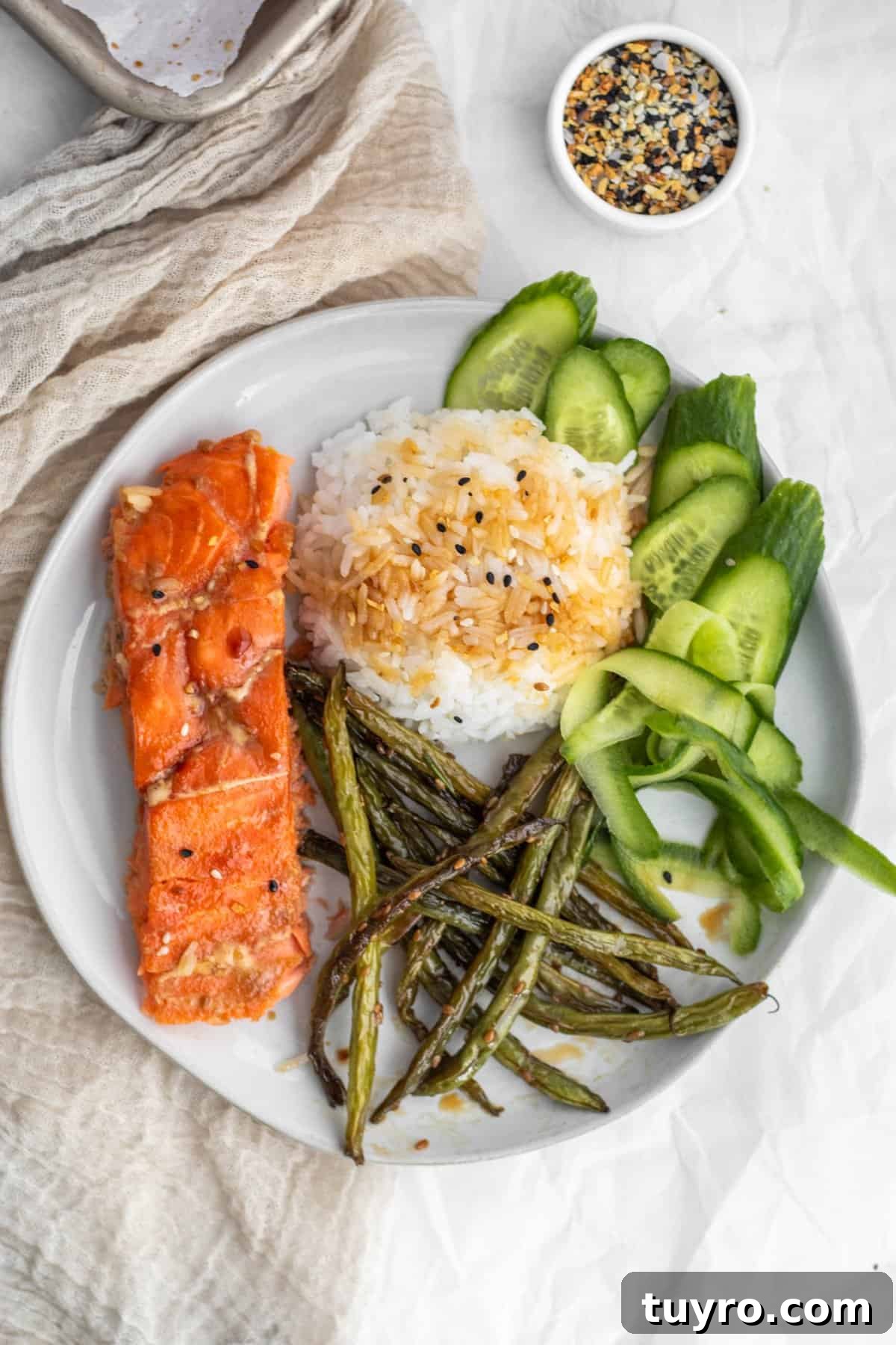 Baked Teriyaki Salmon in 15 Minutes — 2-Ingredient Recipe 7 A plate with salmon, rice, cucumbers and green beans.