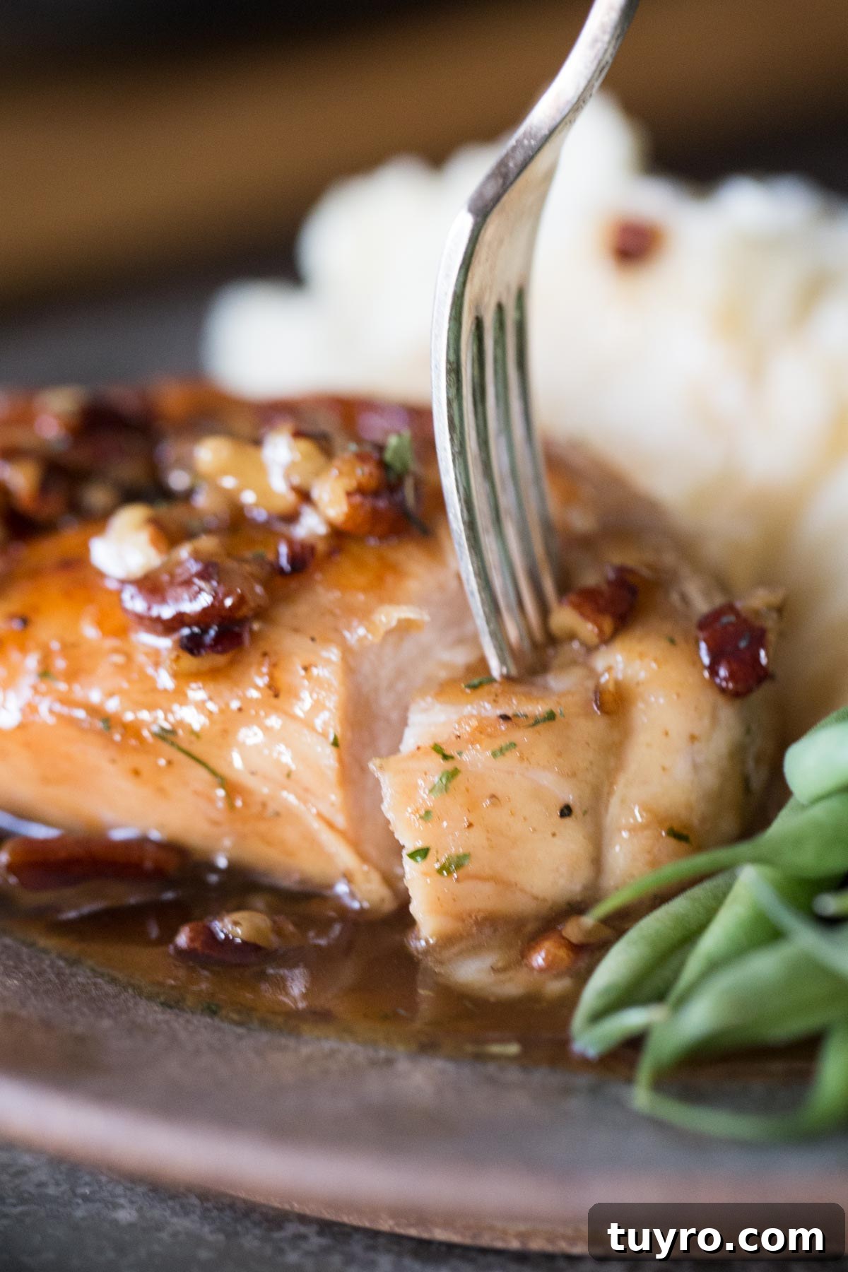 Butter Pecan Chicken Recipe with Crispy Pan-Seared Chicken and Maple Glaze 4 Close up view of bite cut out of Butter Pecan Chicken with a fork.