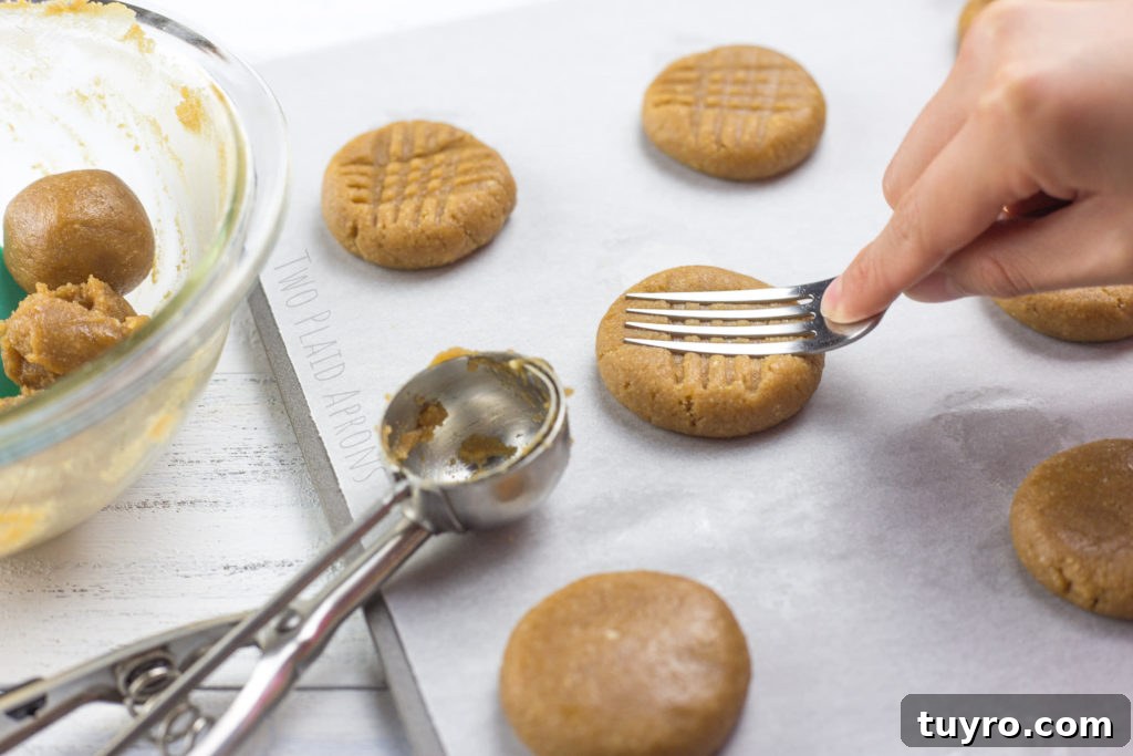 Chewy Gluten-Free Peanut Butter Cookies Recipe 4 Making criss-cross indentions with a fork on gluten free peanut butter cookies.