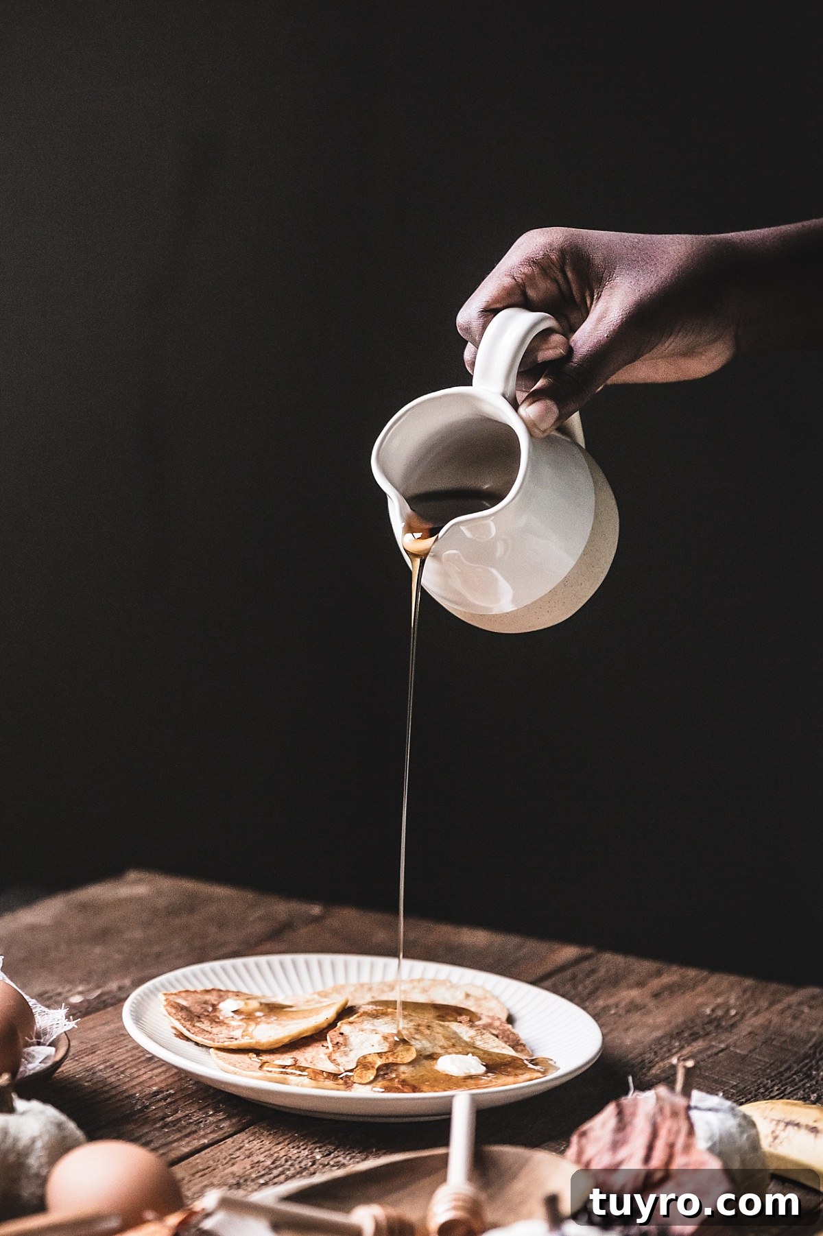 2-Ingredient Banana Pancakes: Egg & Banana Recipe 11 hands pour maple syrup onto simple egg & banana pancakes