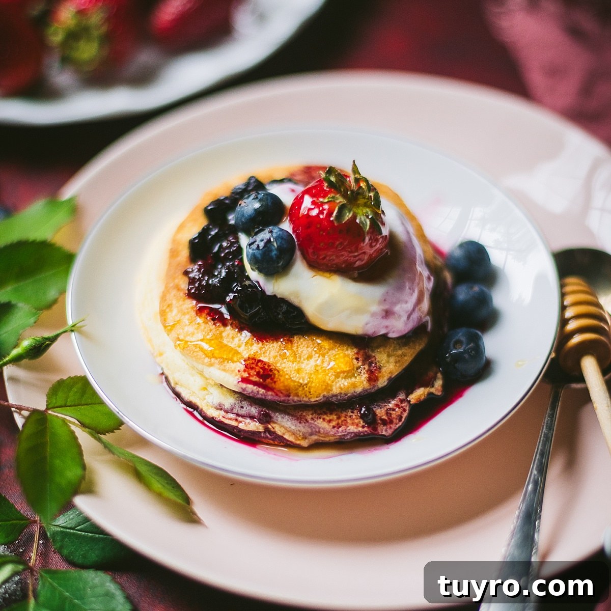 fluffy Polish sweet omelette on a dish stacked like pancakes with fresh cream, blueberries, and strawberry