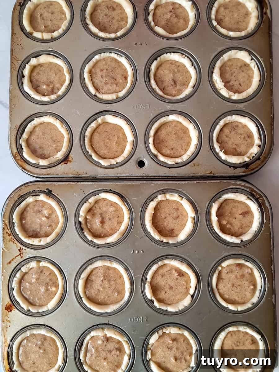 pecan tarts in muffin tins ready to bake.