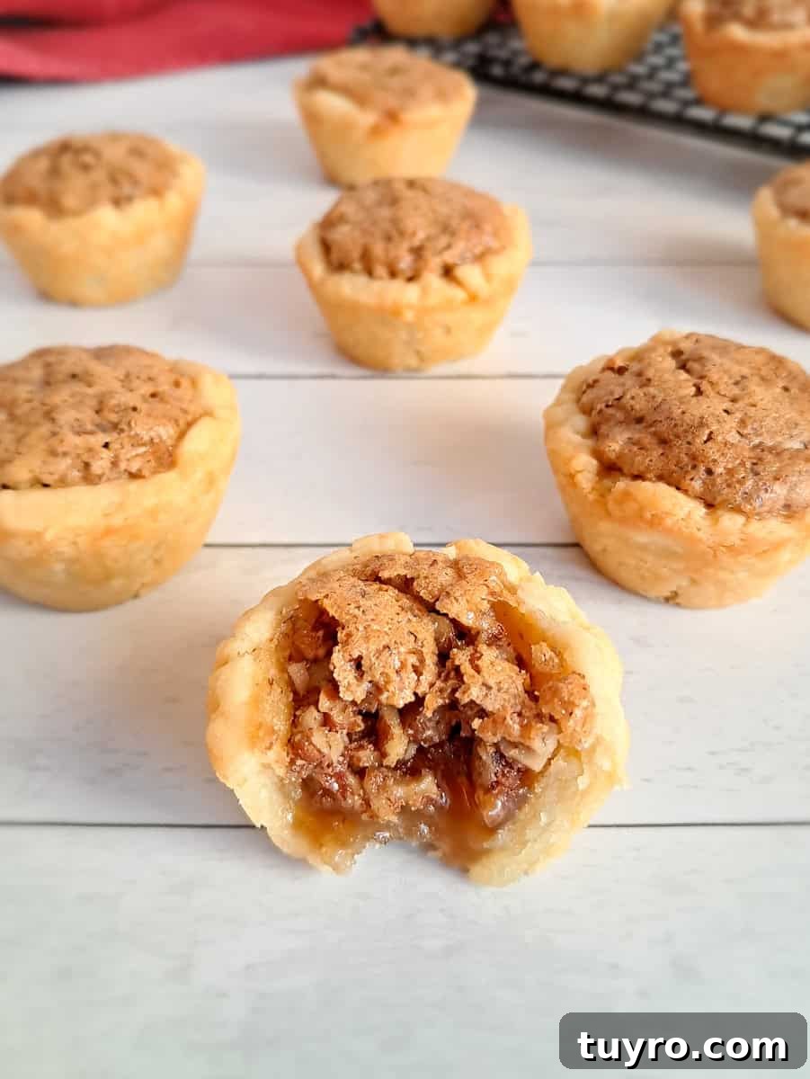 mini Amish pecan tarts scattered around, one has a bite out of it so you can see the filling.