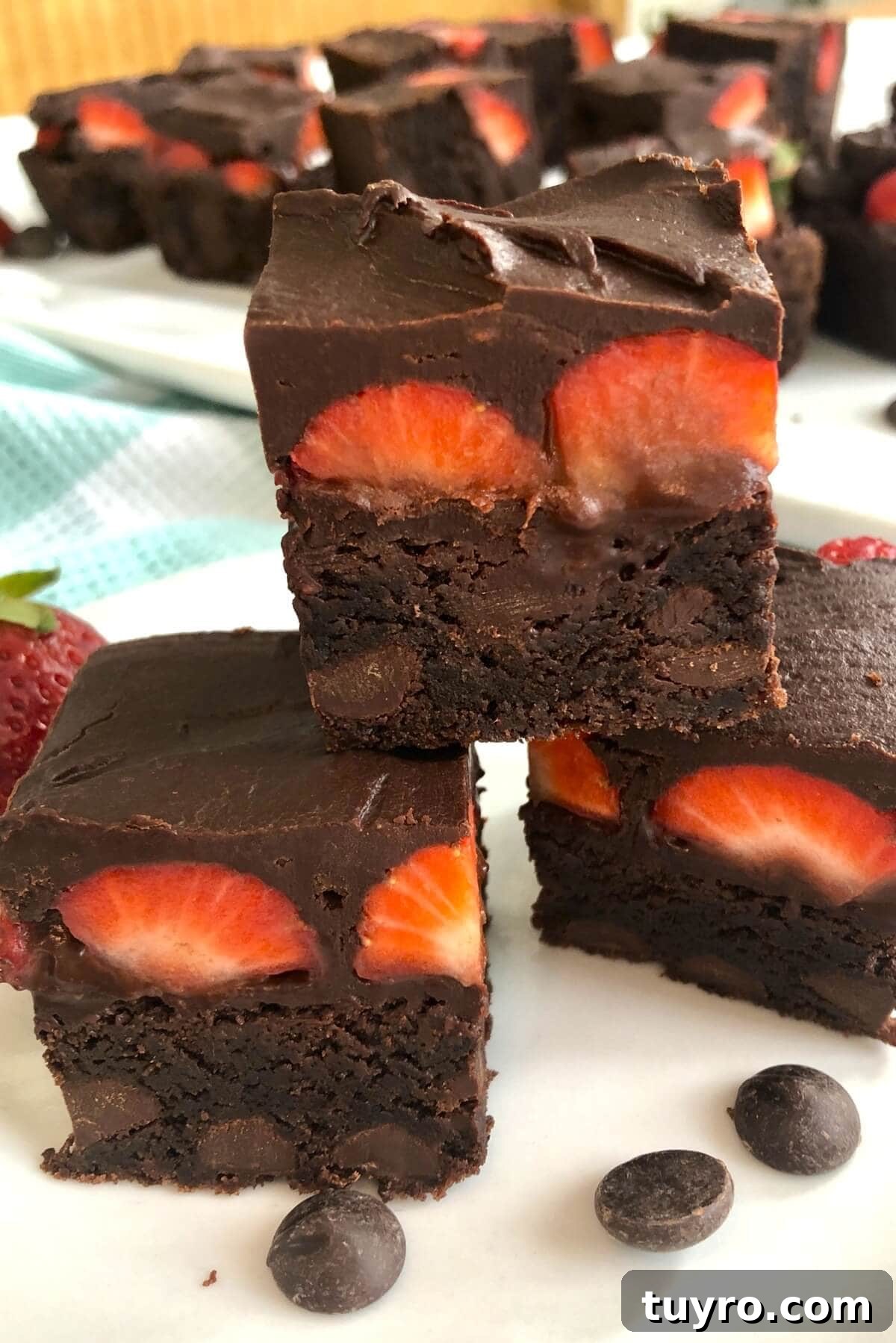 3 brownies with strawberries in a stack.