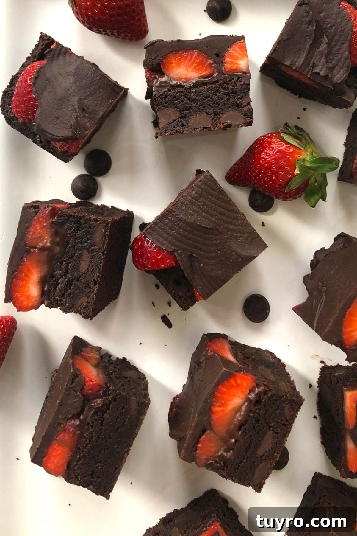 Small brownies with fresh strawberries and chocolate icing.