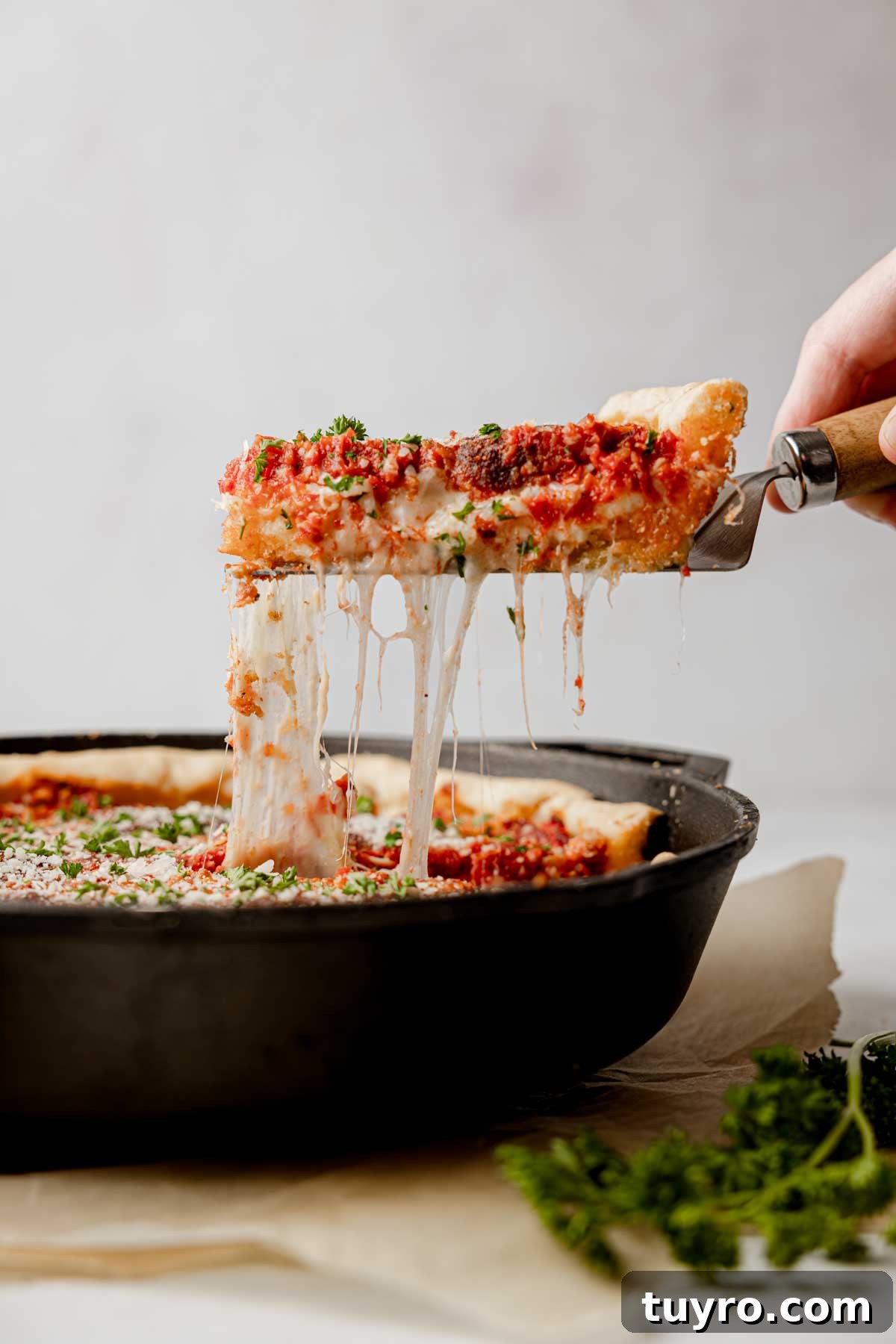 Authentic Chicago-Style Gluten-Free Deep Dish Pizza Recipe 11 Slice of pizza lifted from pan with cheese pull.