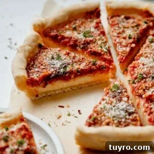 Authentic Chicago-Style Gluten-Free Deep Dish Pizza Recipe 14 Gluten free Chicago deep dish pizza with sauce on top, sliced and resting on parchment paper, sprinkled with parmesan and parsley.