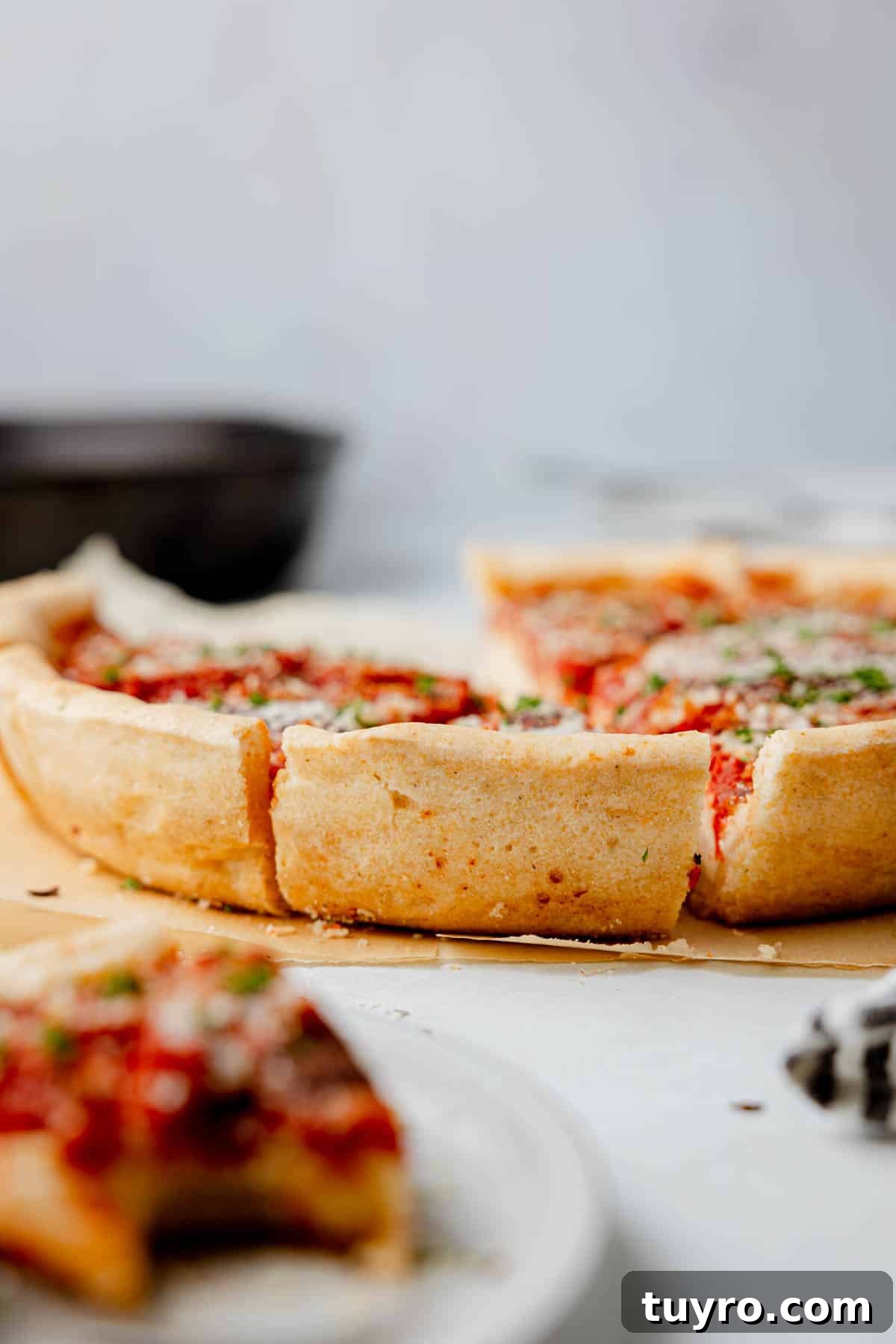 Authentic Chicago-Style Gluten-Free Deep Dish Pizza Recipe 3 Gluten free deep dish pizza sliced, resting on parchment showing high sided crust.