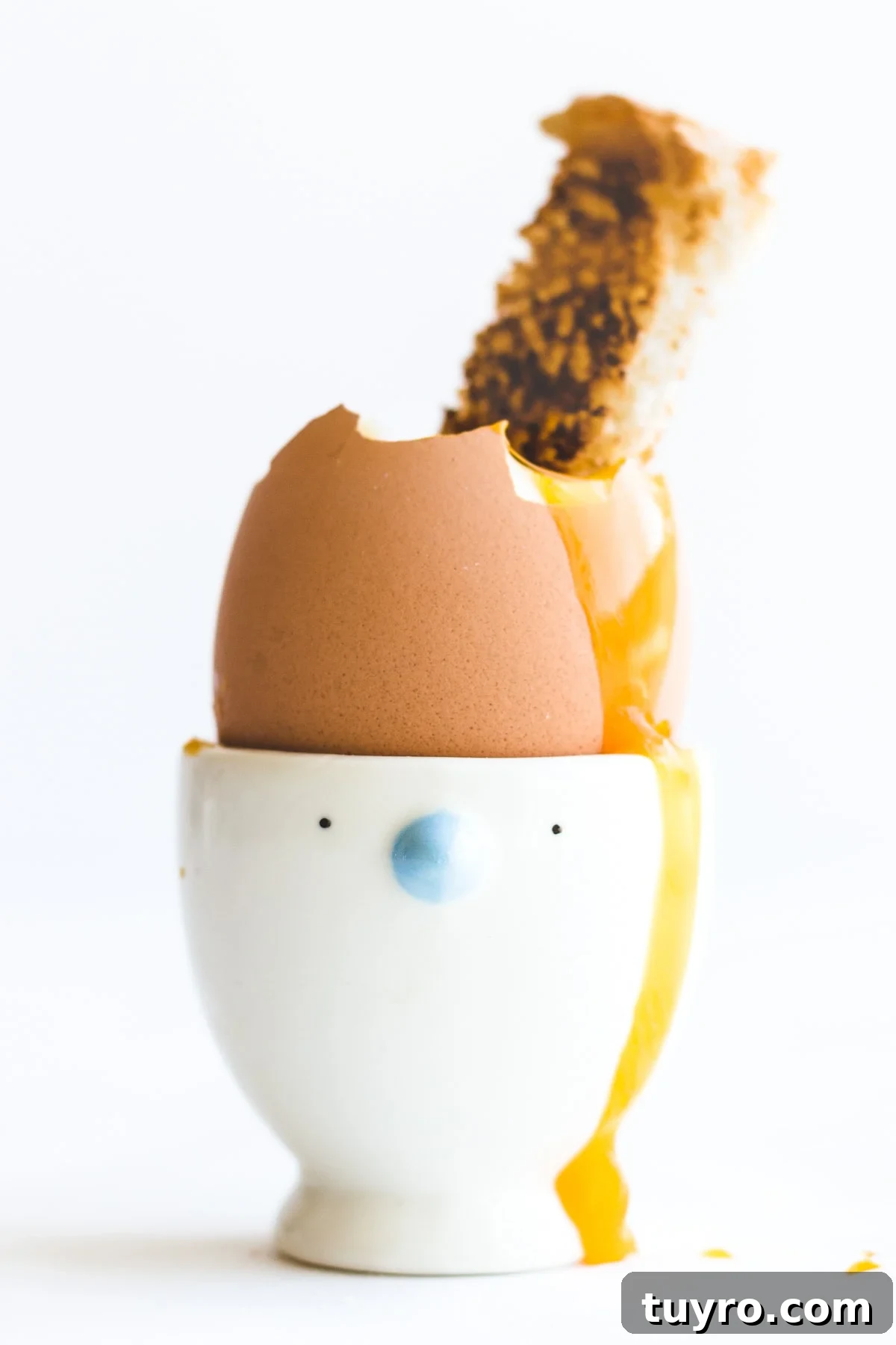 How to Make Creamy Soft-Boiled Eggs Every Time 2 Soft boiled egg in an egg cup with top off and toast solider dipped in.