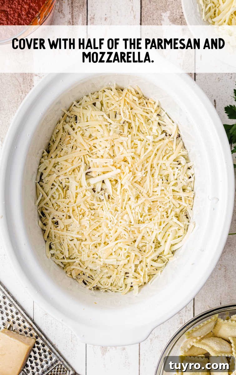 Crockpot Lasagna process shot of lasagna covered with shredded parmesan and mozzarella