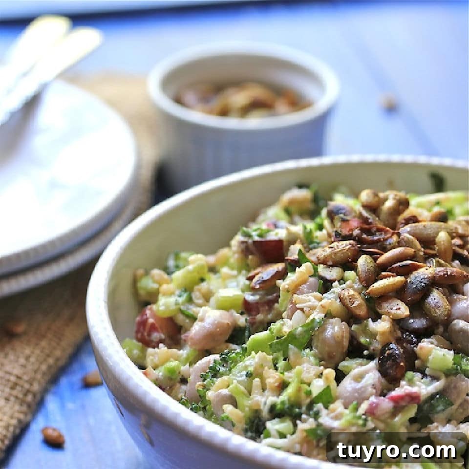 Side view of broccoli and bean salad topped with roasted pumpkin seeds.
