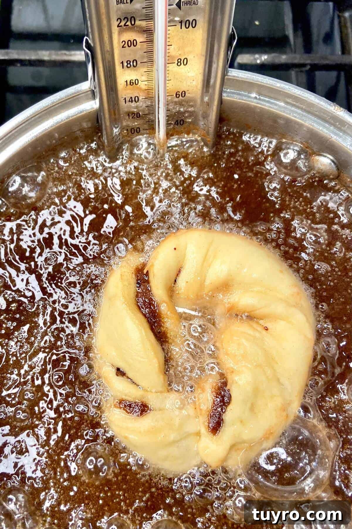 Cinnamon Roll Donuts: Soft Swirls with Cream Cheese Glaze 14 Placing donut in oil.