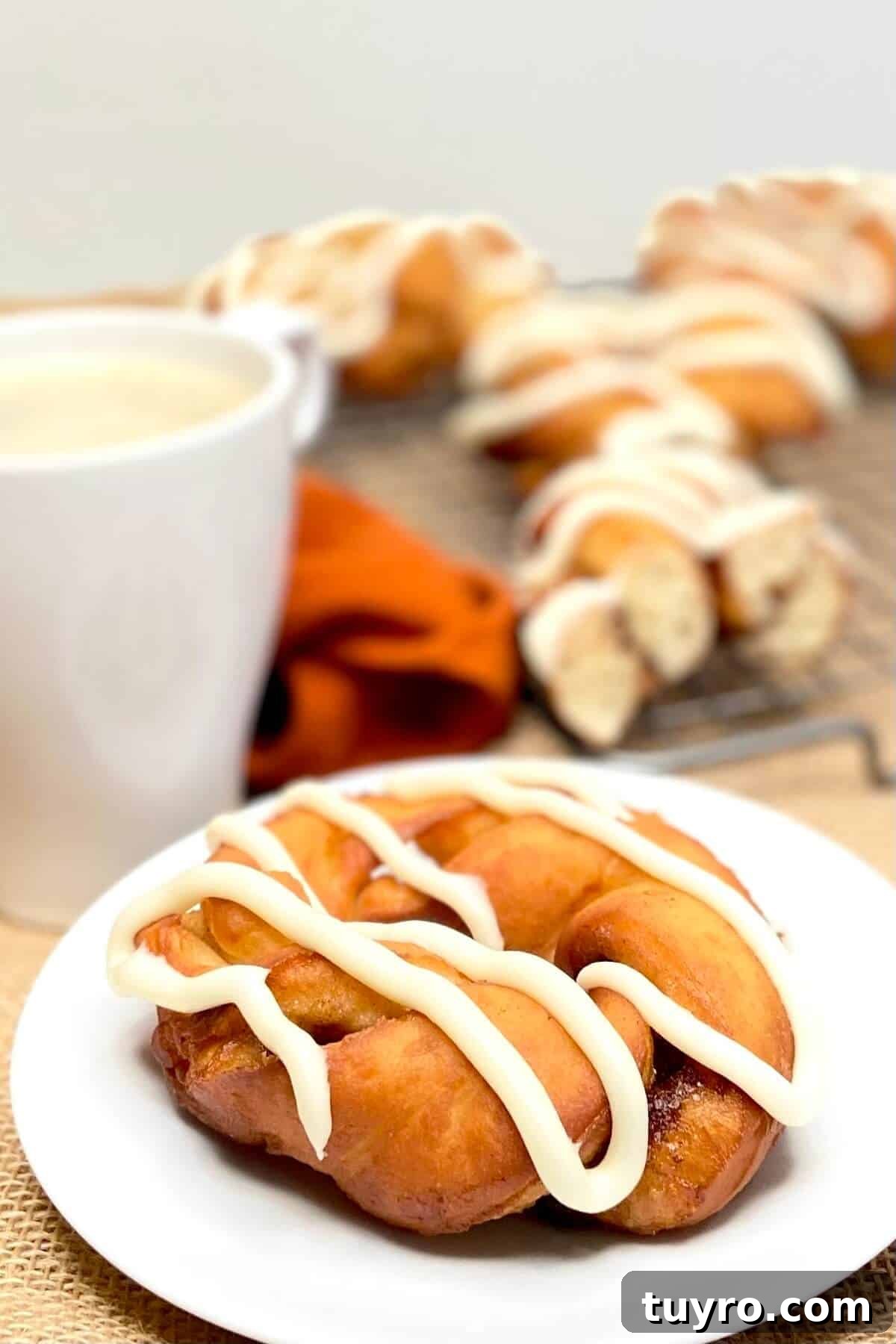 Cinnamon Roll Donuts: Soft Swirls with Cream Cheese Glaze 4 Donut served on a round white plate.