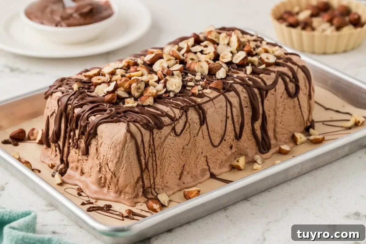 Chocolate Hazelnut Semifreddo cake topped with chopped hazelnuts and chocolate drizzle on a baking tray.