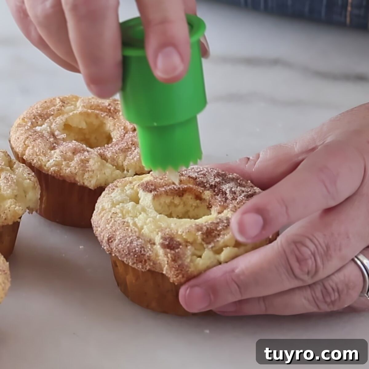 coring cupcakes using green plastic cupcake corer.