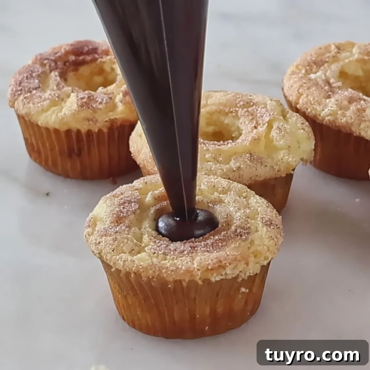 filling cupcakes with chocolate ganache.