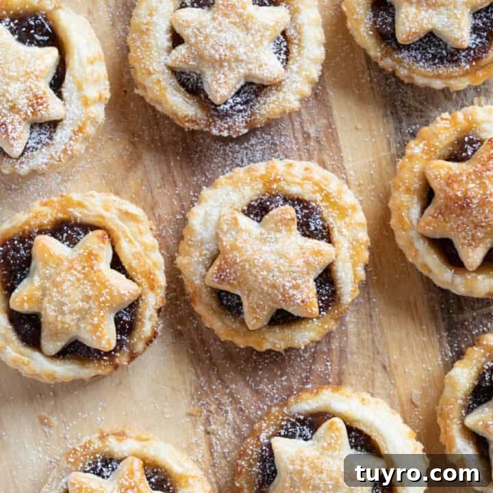 Puff pastry mince pies on a wooden board.